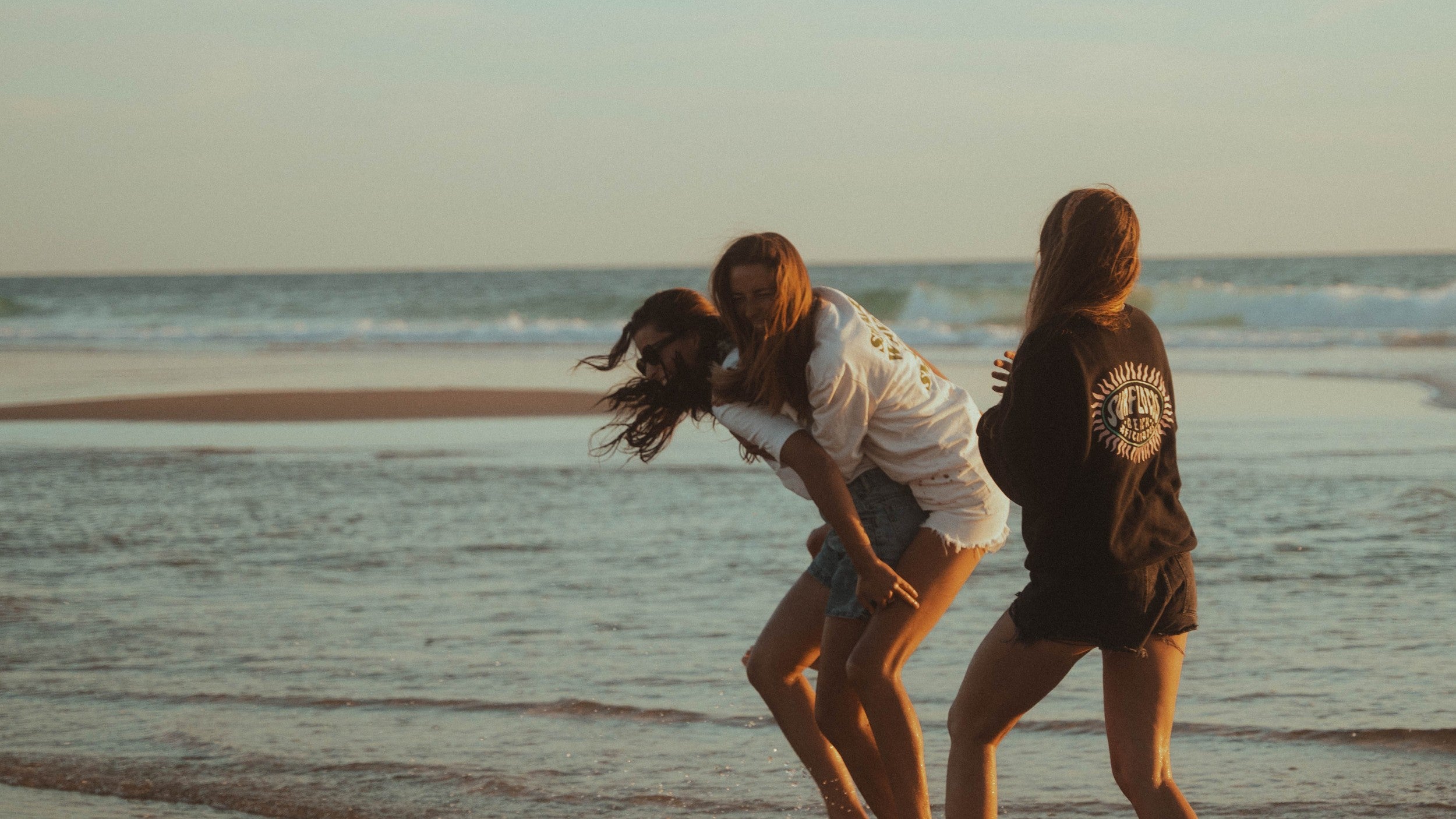 Femmes jouant sur la plage au bord de l'eau