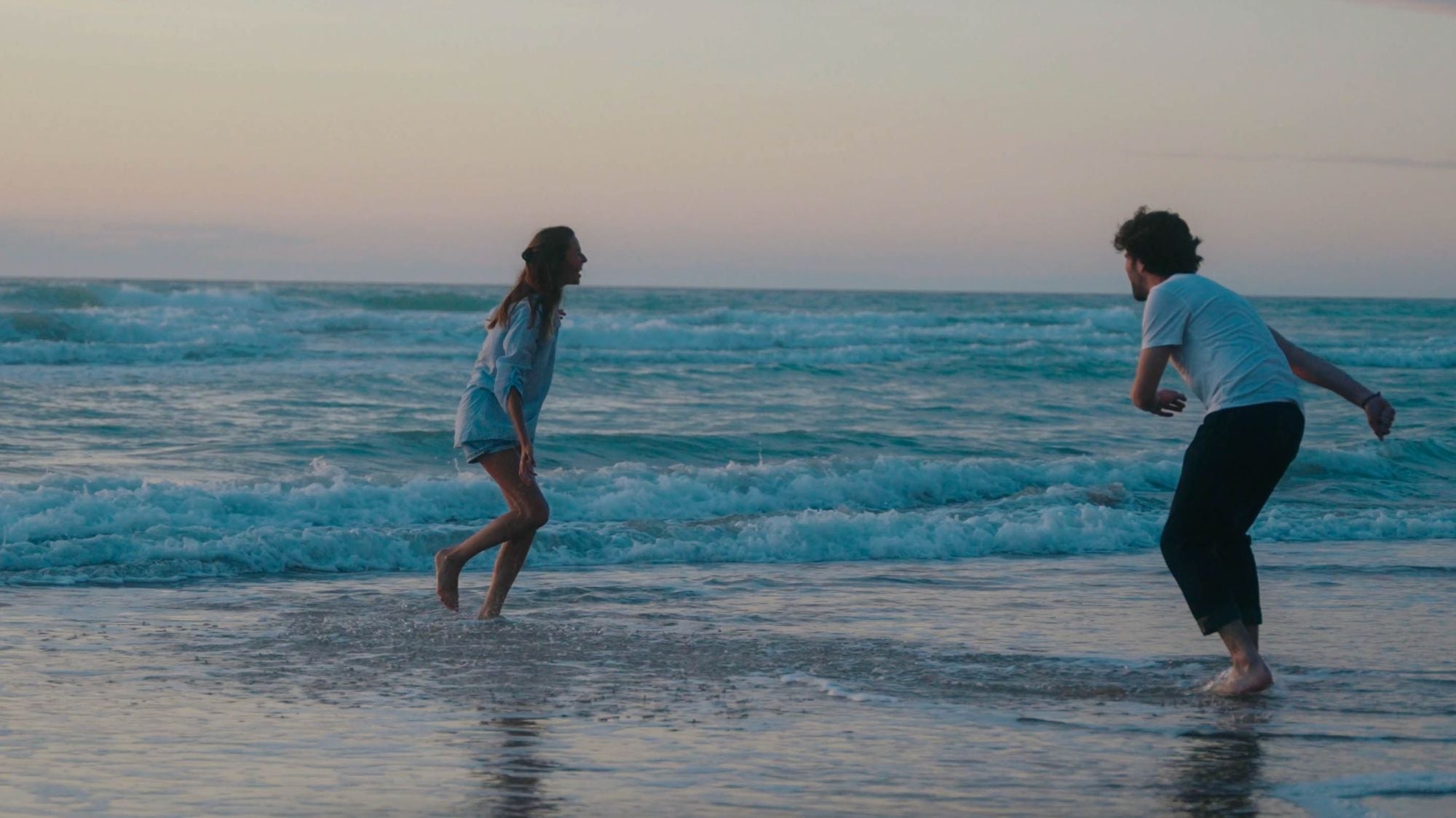 Homme et femme qui jouent au bord de l'eau